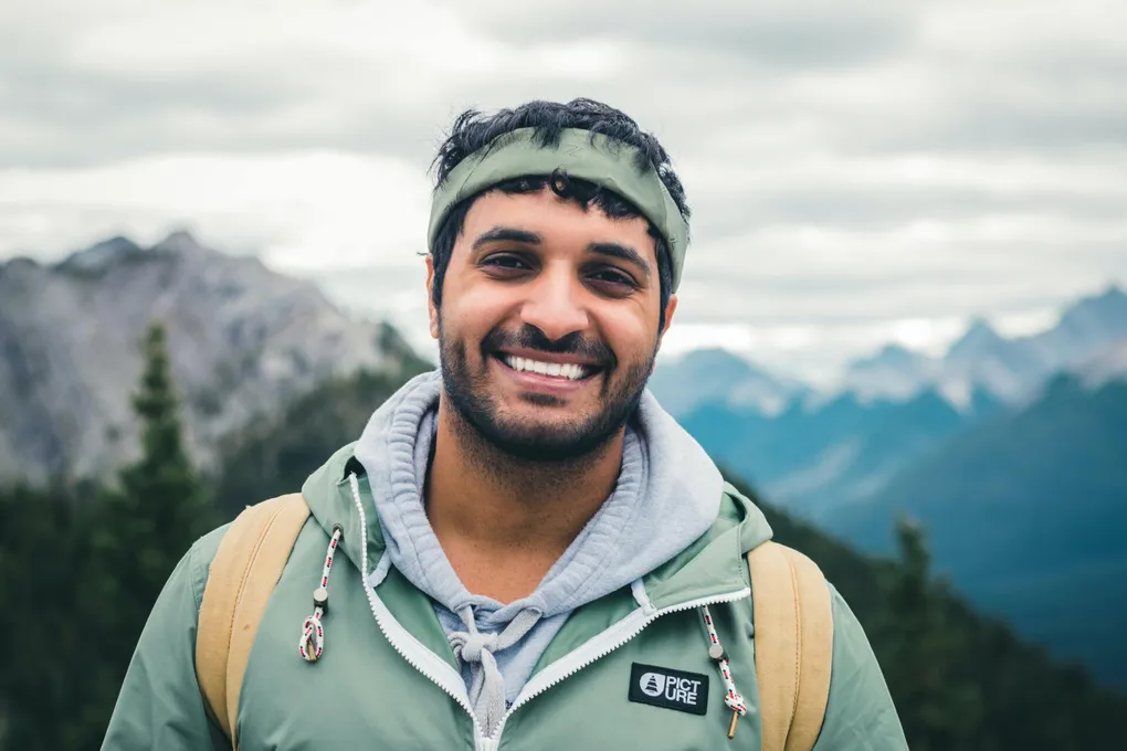 ali-kazal-mpPfqvh04Fc-unsplash-1020w A man with a backpack and hat on.
