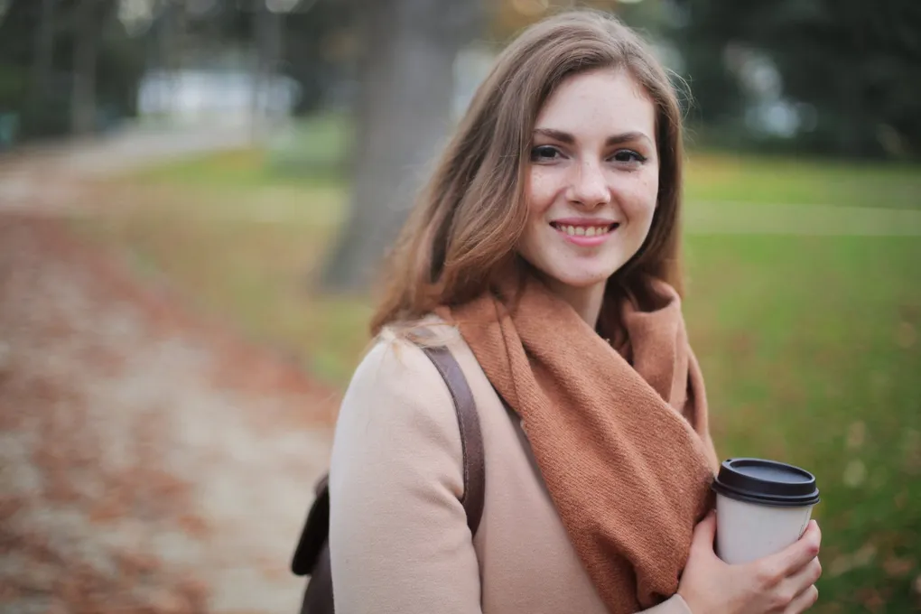 pexels-photo-712513-1020w A woman in a brown scarf holding a coffee cup.