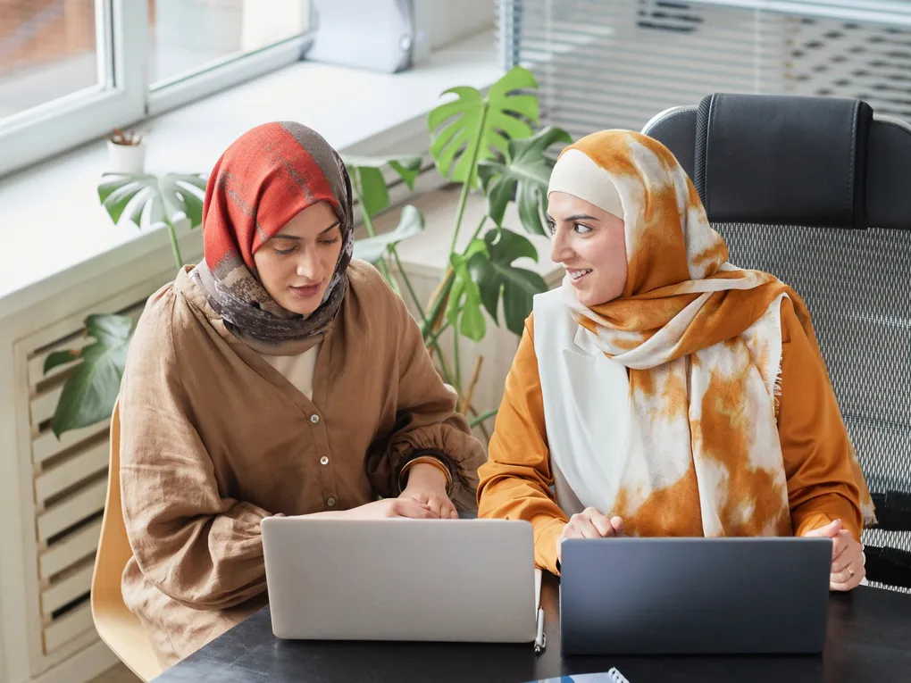 pexels-photo-8154231-7c236587-1020w Two women sitting at a table looking at a laptop.